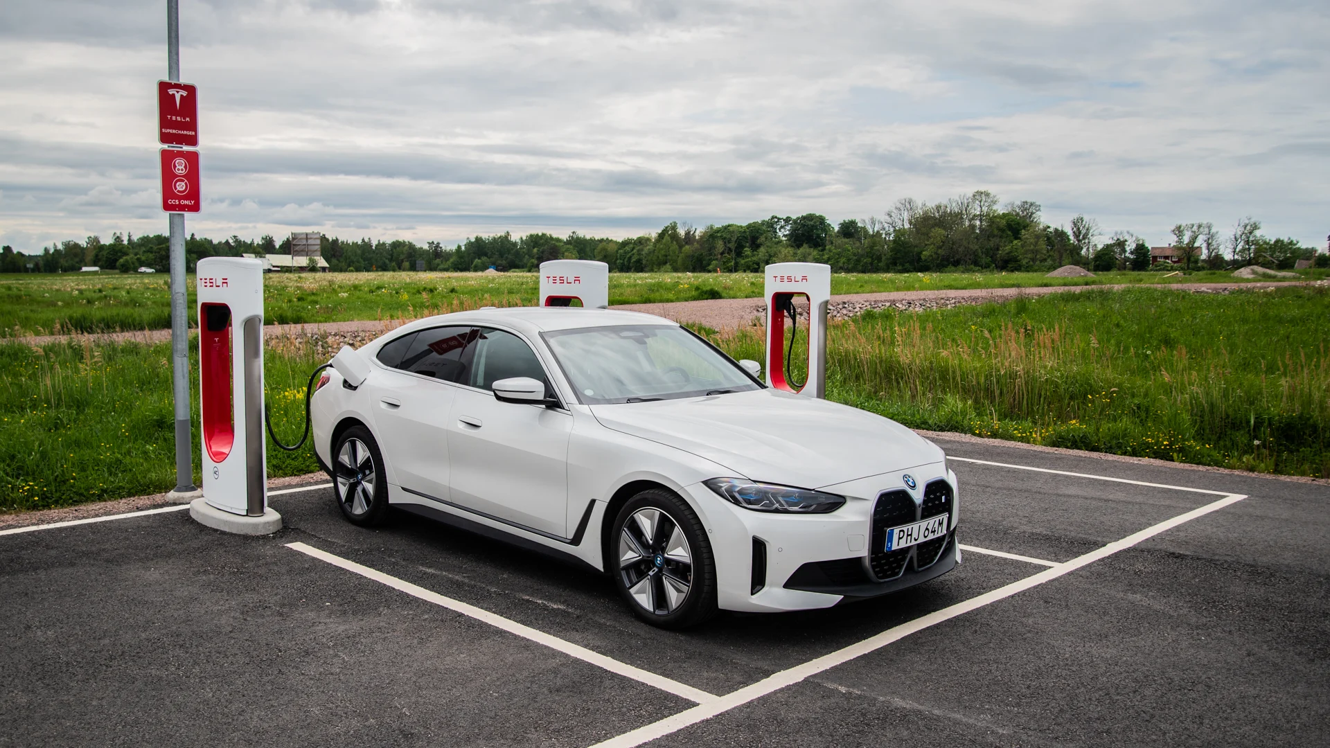 Vit elbil laddar vid snabbladdare