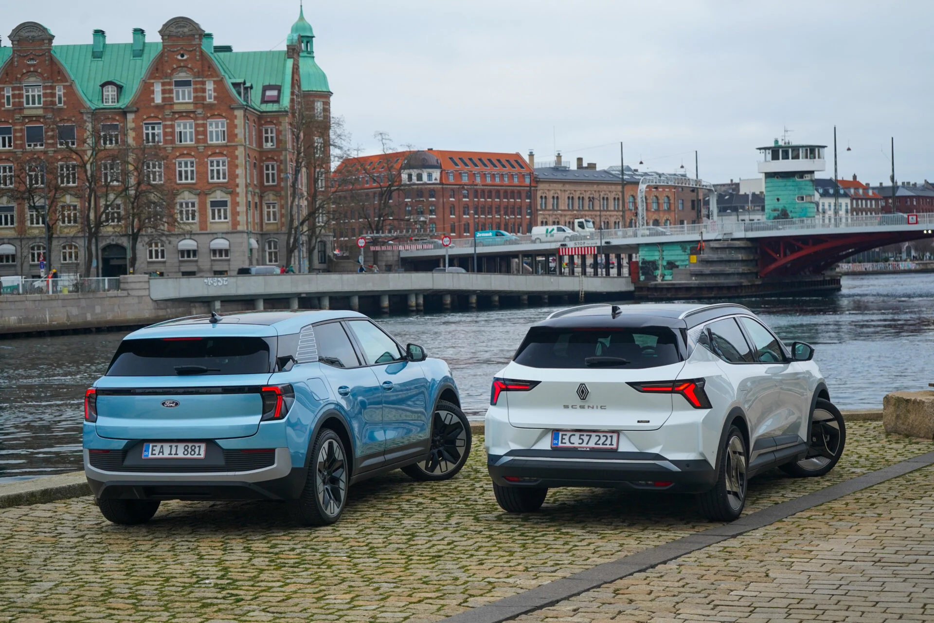 Blå Ford Explorer och vit Renault Scenic E-Tech parkerade vid kaj