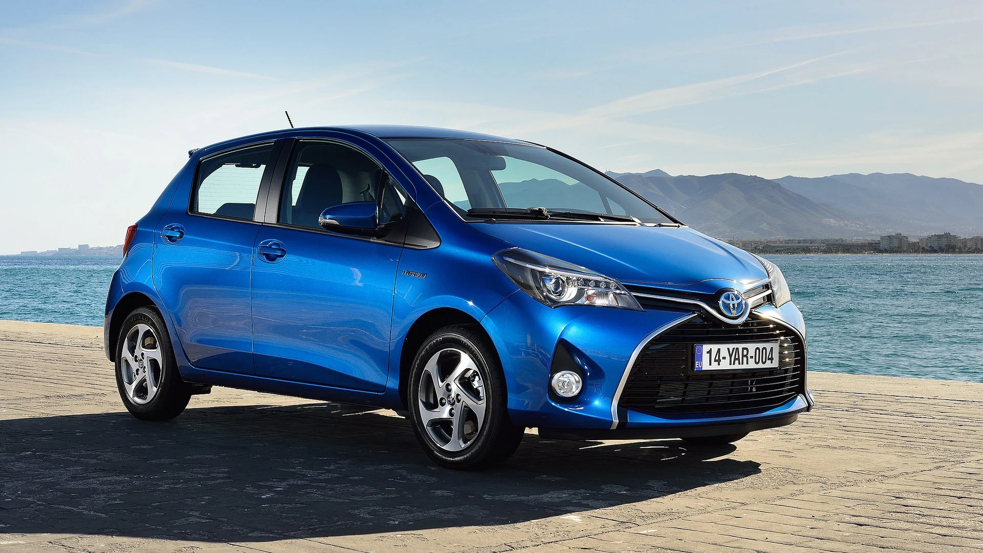 Blå Toyota Yaris parkerad vid vatten