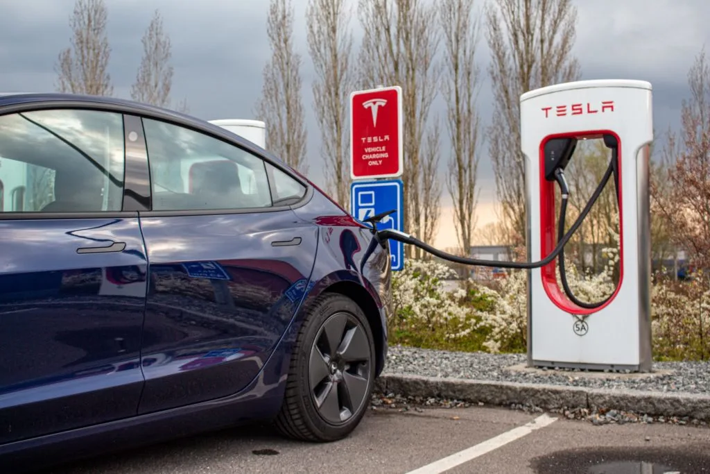 Tesla parkerad vid laddstation laddas