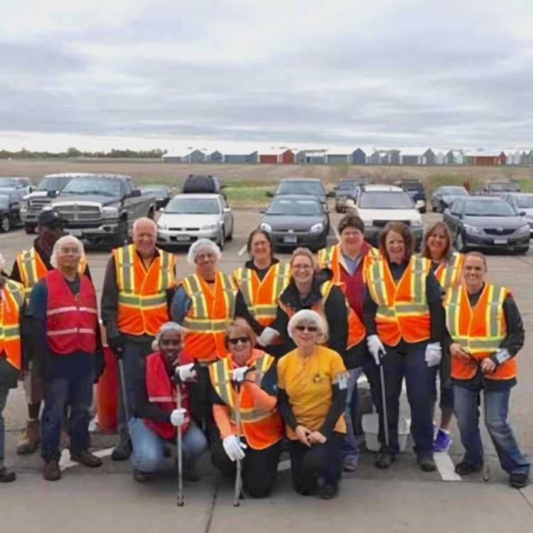 A team of Hearthside employees in orange safety vests pose for a photo