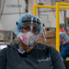 A woman wearing a mask and a Hearthside shirt.