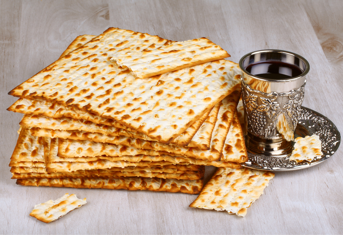 A tall stack of well-crisped unleavened crackers next to a silver goblet