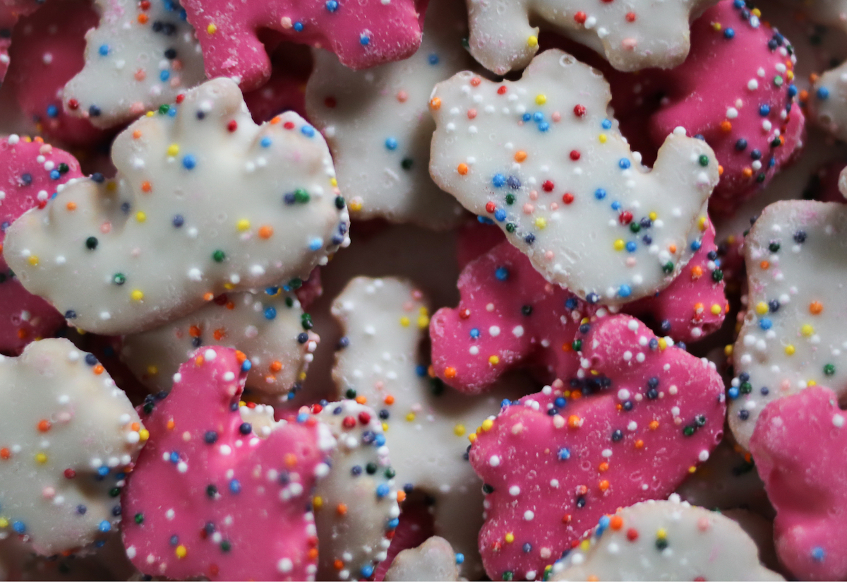 Rotary cookies with pink and white frosting and colorful sprinkles