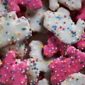 Rotary cookies with pink and white frosting and colorful sprinkles