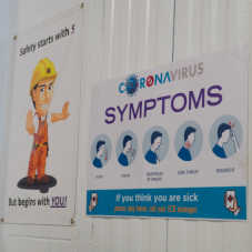 A sign reading 'Coronavirus Symptoms,' detailing what sort of symptoms to watch for