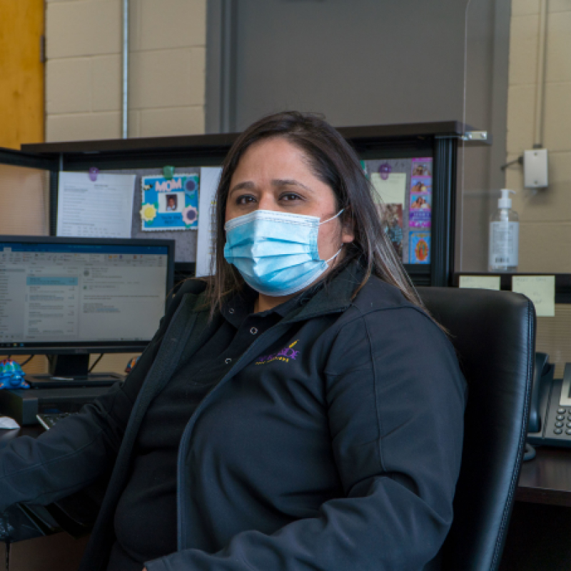 A Hearthside employee sits in a computer seat, with a computer monitor to her right