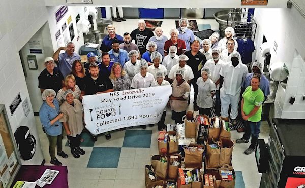 Lakeville employees hold a large banner for a food drive.
