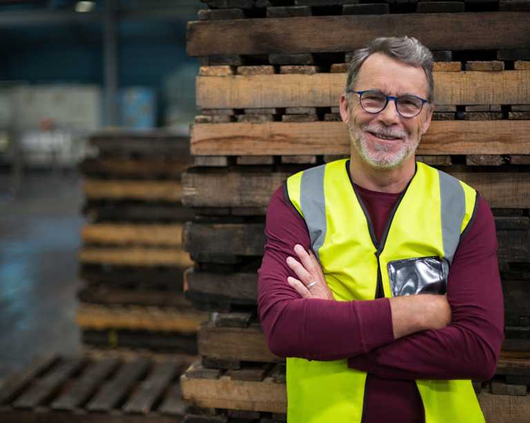 A Hearthside employee wearing a maroon sweater and yellow safety vest