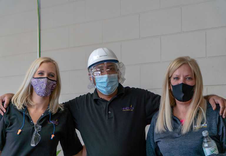 Three masked Hearthside workers stand side-by-side against a white wall.