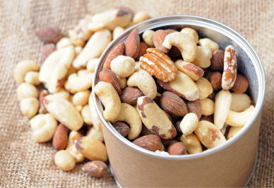 A rigid canister pours over with mixed nuts