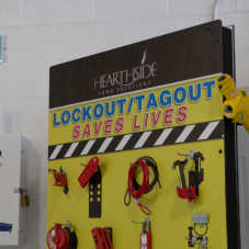 A sign with hanging tools, reading 'Lockout/Tagout Saves Lives'