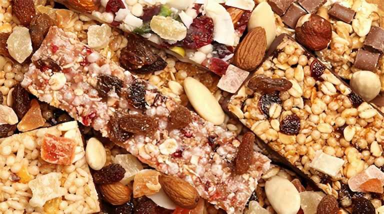 A pile of granola bars with various nuts and fruits.