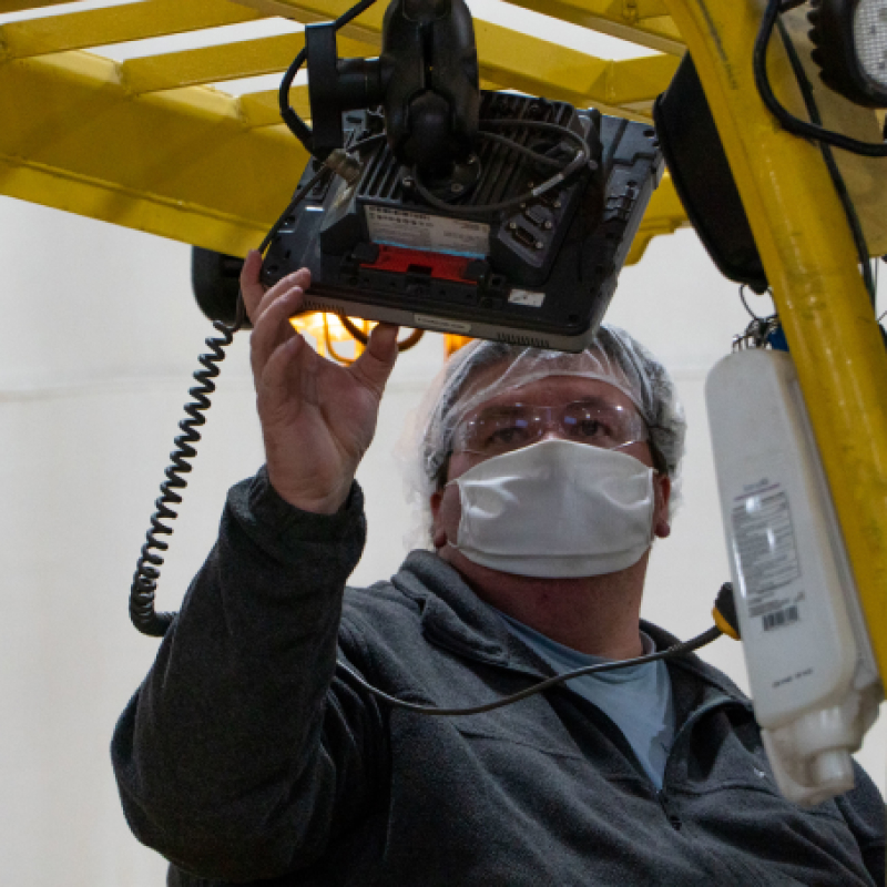 A masked Hearthside worker monitoring a screen