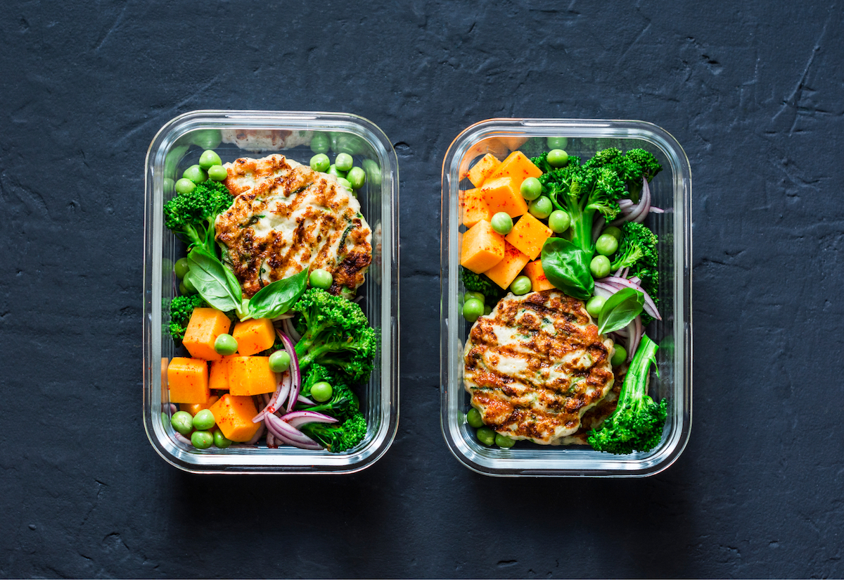 Two salad kits sitting side-by-side, loaded with fresh vegetables
