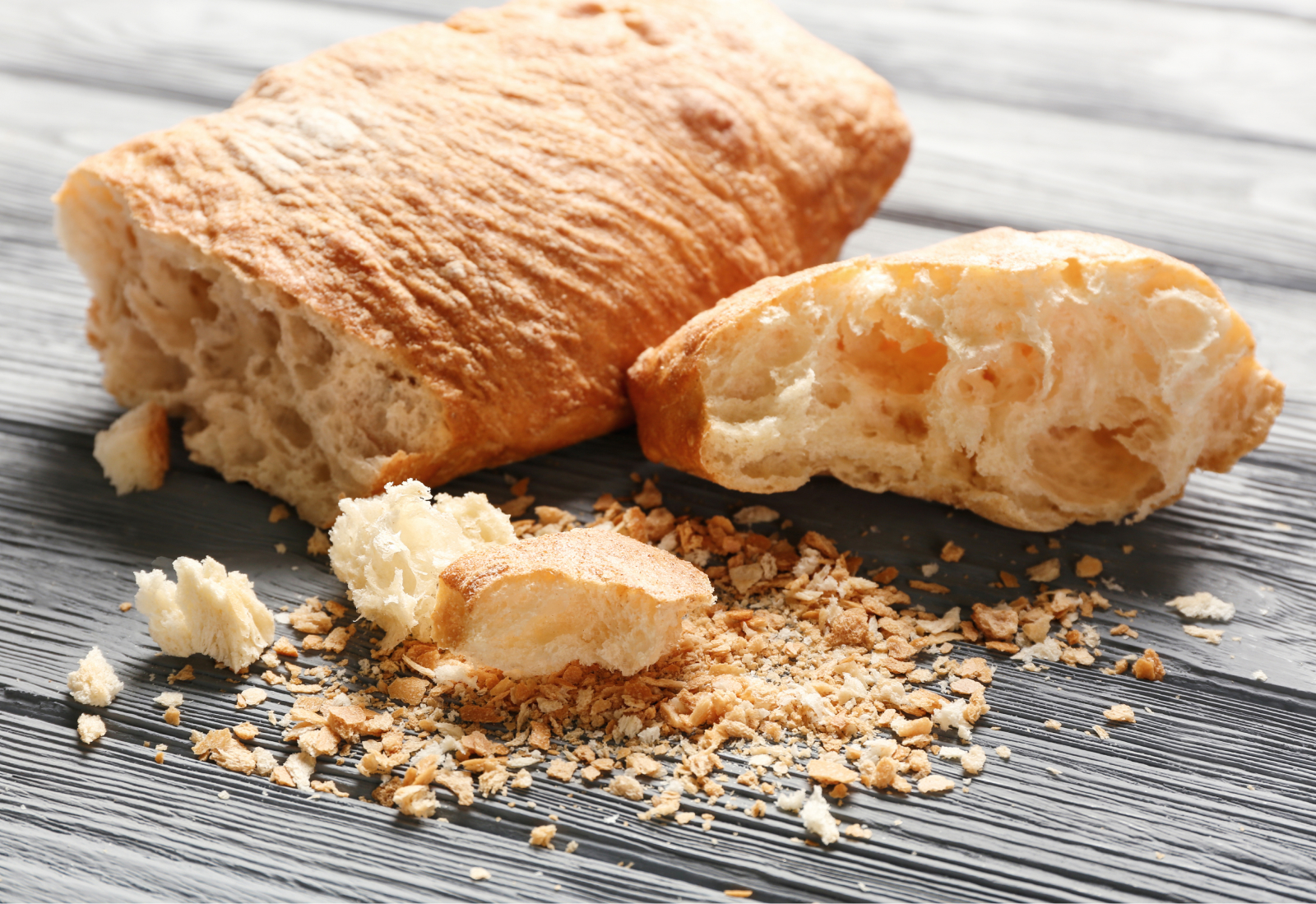 Dry bread crumbles onto a wooden table
