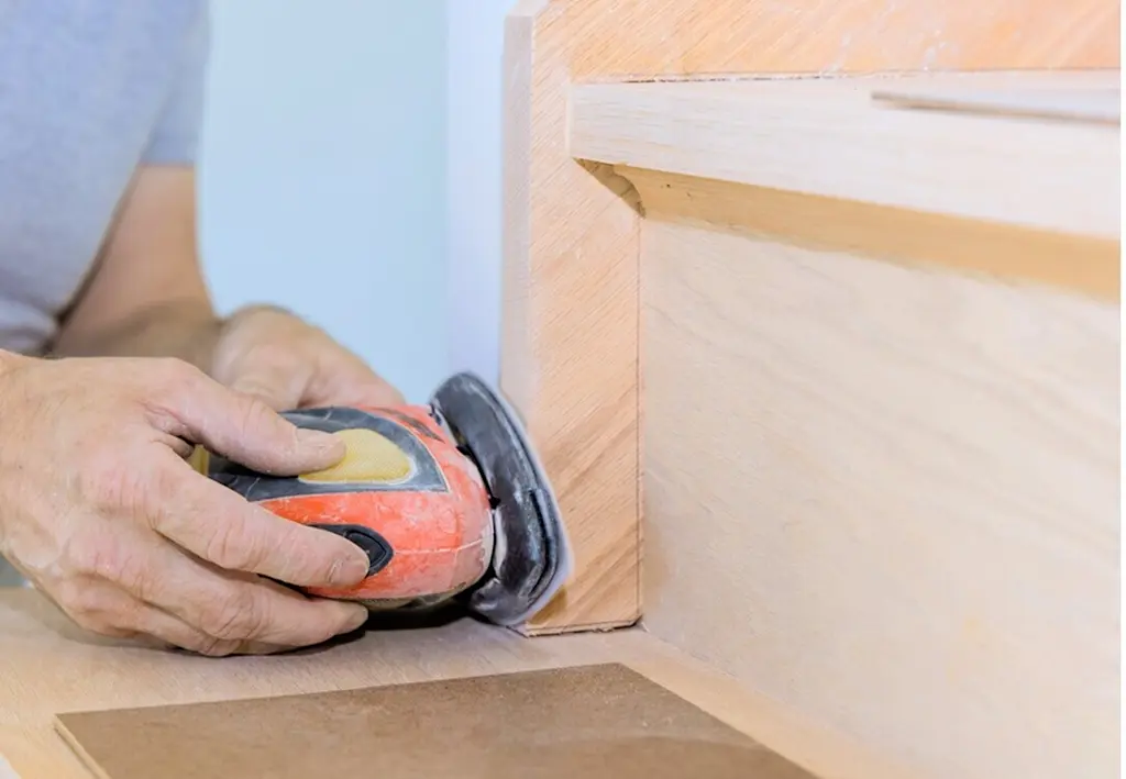 Sanding down wooden staircase