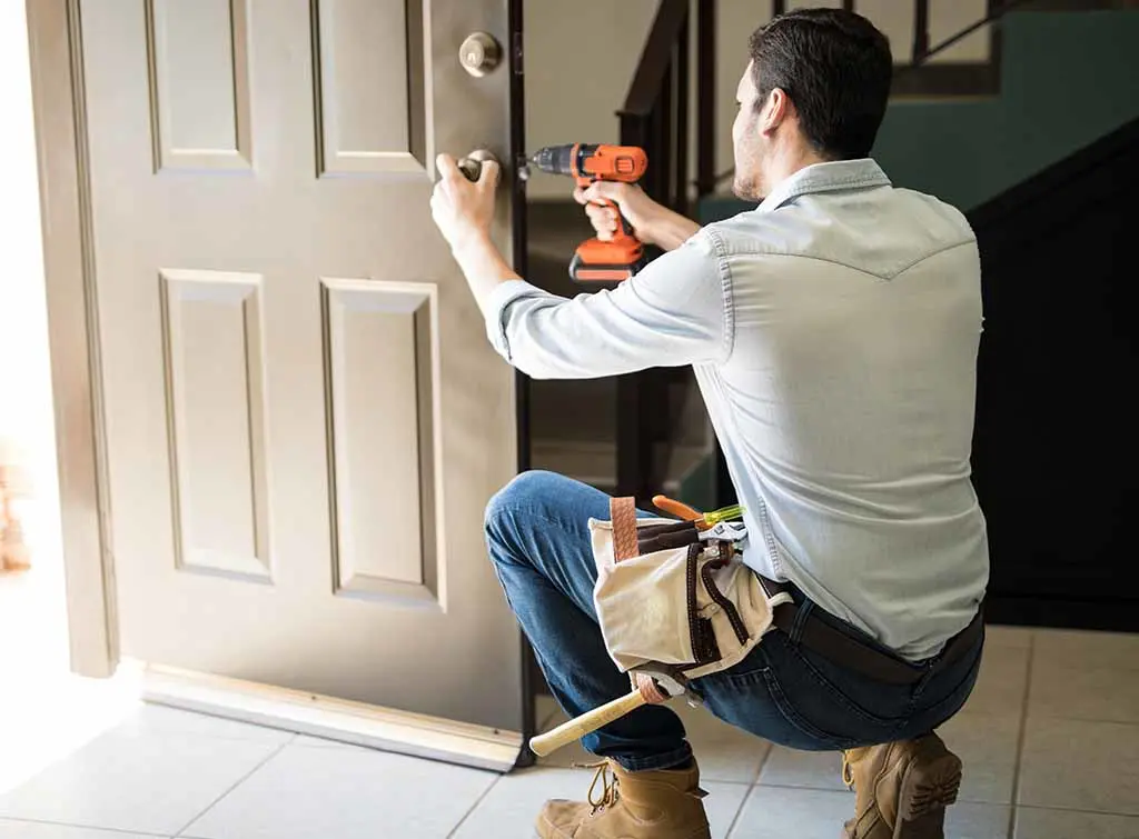 Handyman fixing a door lock