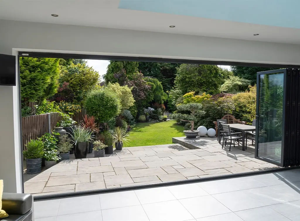 View of the garden from a kitchen through open bi-fold doors