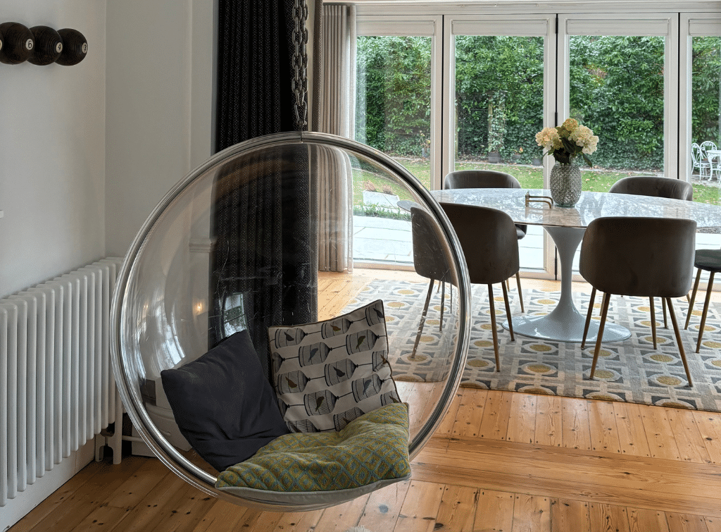 A retro hanging bubble chair suspended from the ceiling in the living room