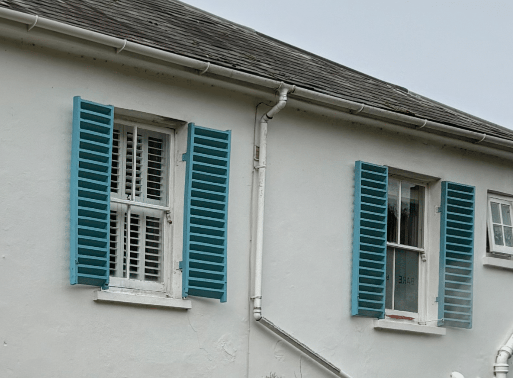 Victorian property, the House with the Blue Shutters, features contrasting blue shutters against a crisp white render