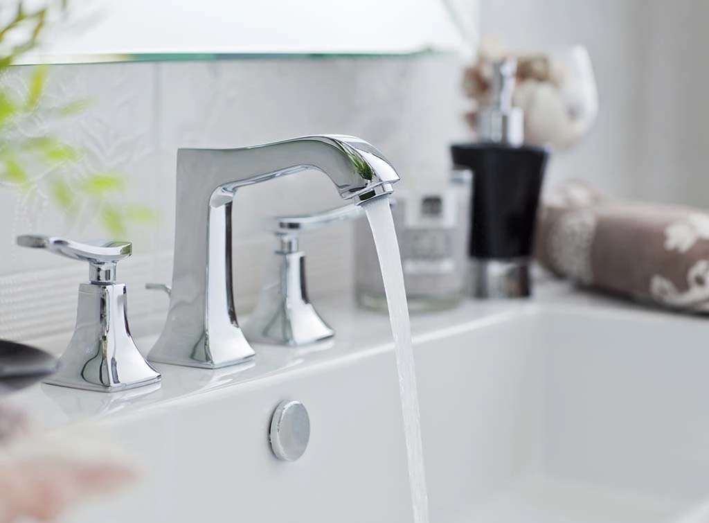 Sparkling bathroom taps with water flowing