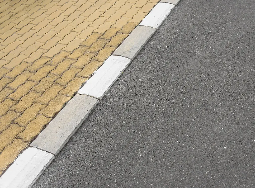 https://www.checkatrade.com/blog/wp-content/uploads/2020/07/dropped-kerb-onto-brickwork-driveway.jpeg