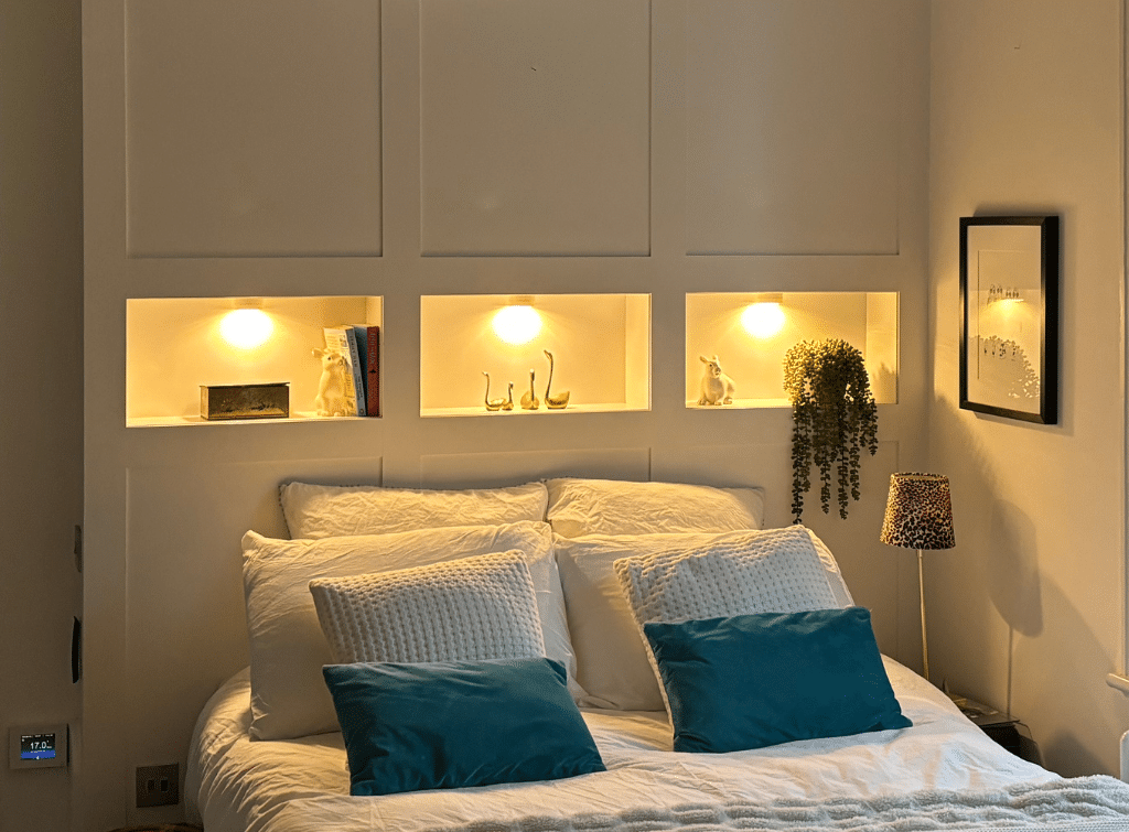 Integrated lighting in the alcoves of this built-in headboard wall is practical and cosy