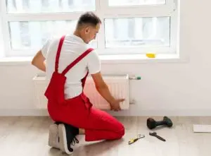 Plumber replacing a leaking radiator