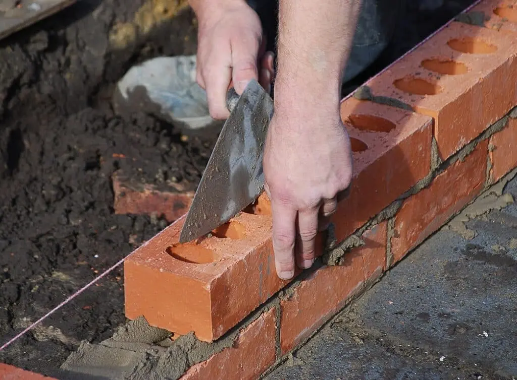 https://www.checkatrade.com/blog/wp-content/uploads/2024/09/bricklayer-constructing-a-wall-1024x754.jpeg