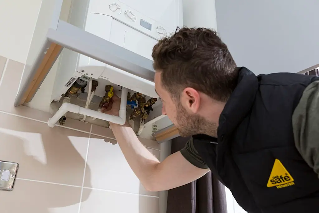 Gas safe engineer checks a gas boiler