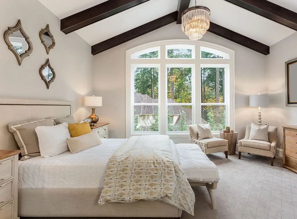 Chandelier hung in a bedroom with vaulted ceiling