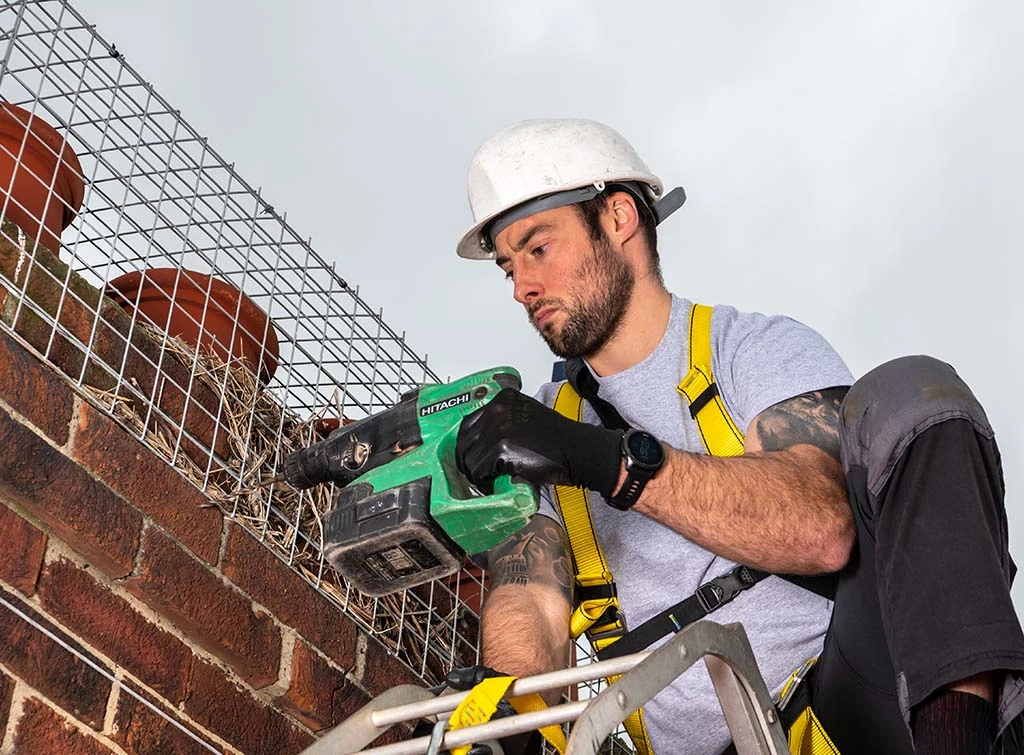 https://www.checkatrade.com/blog/wp-content/uploads/2024/03/rooftop-safety-using-harness.jpg