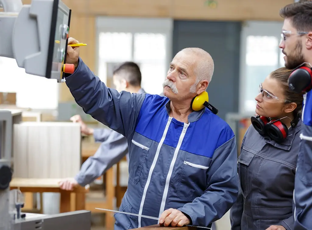 https://www.checkatrade.com/blog/wp-content/uploads/2024/02/engineer-training-with-apprentices.jpg