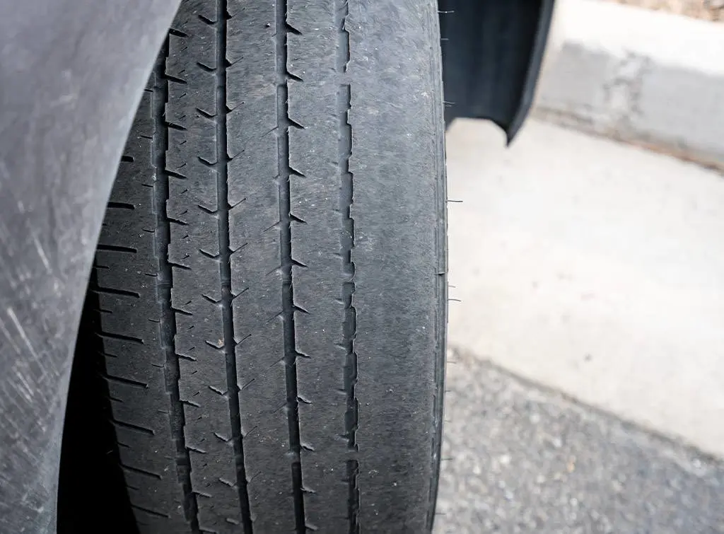 Badly worn tyres on front axle of car