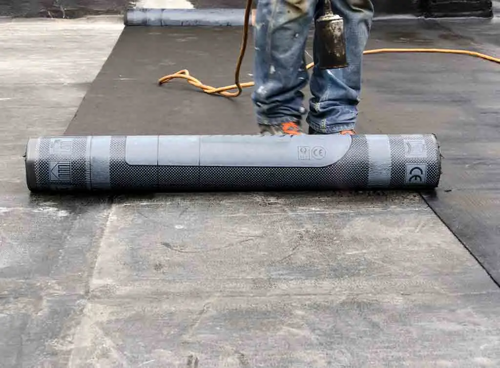 Rubber roof installer laying new roof