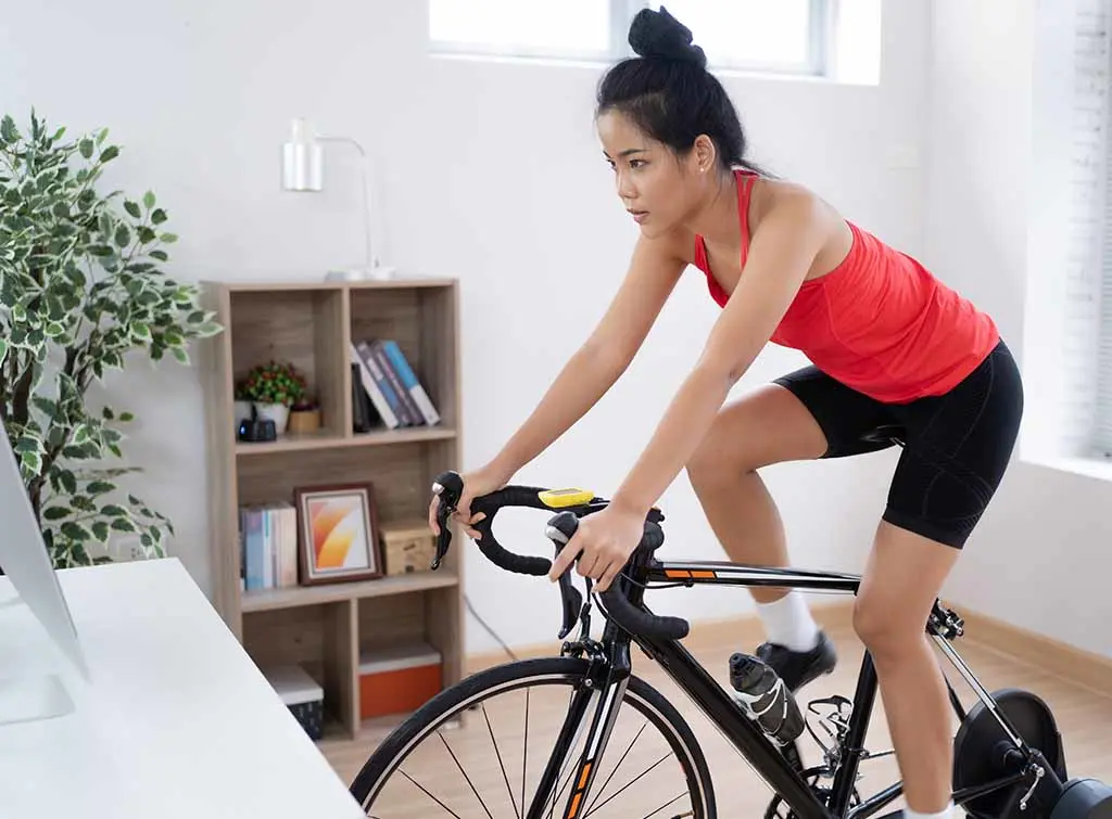 spin studio design idea for the home - women cycling on a turbo trainer indoors
