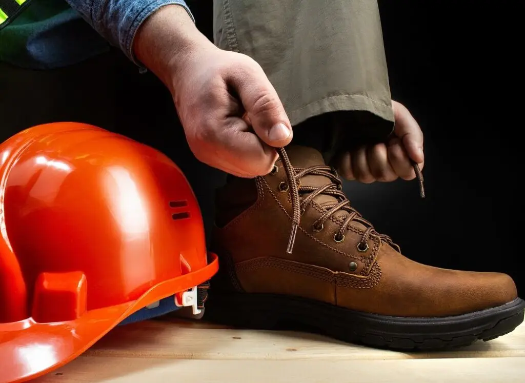 https://www.checkatrade.com/blog/wp-content/uploads/2022/01/putting-on-ppe-work-boots-1024x747.jpeg