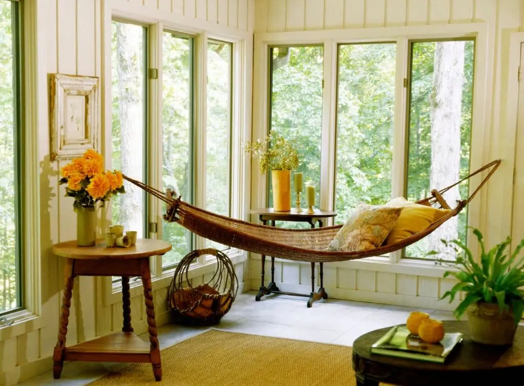 Dreamy conservatory with hammock and rustic decor