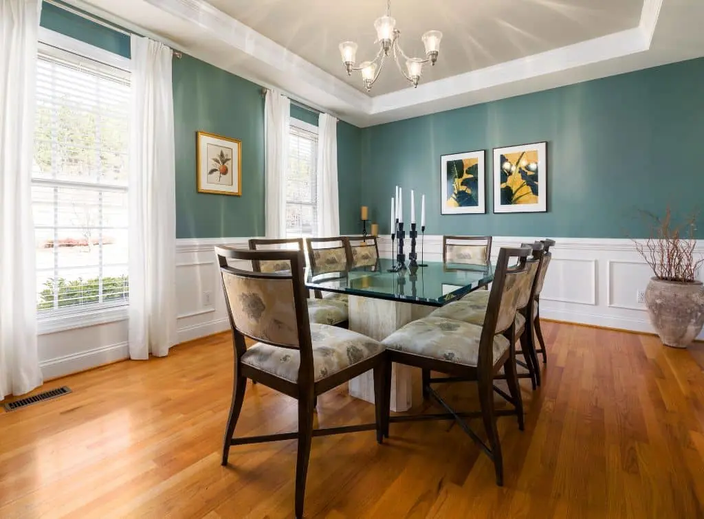 Muted dining room with teal walls, organza curtains and simple mouldings