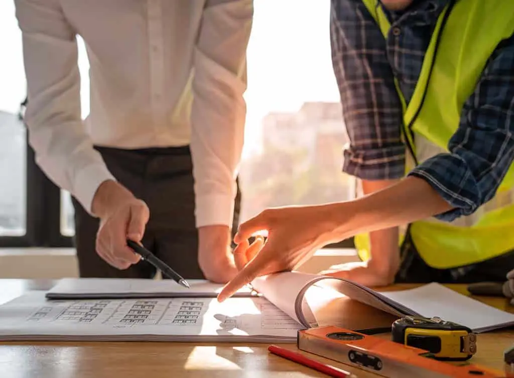Boss and construction worker reviewing the project paperwork
