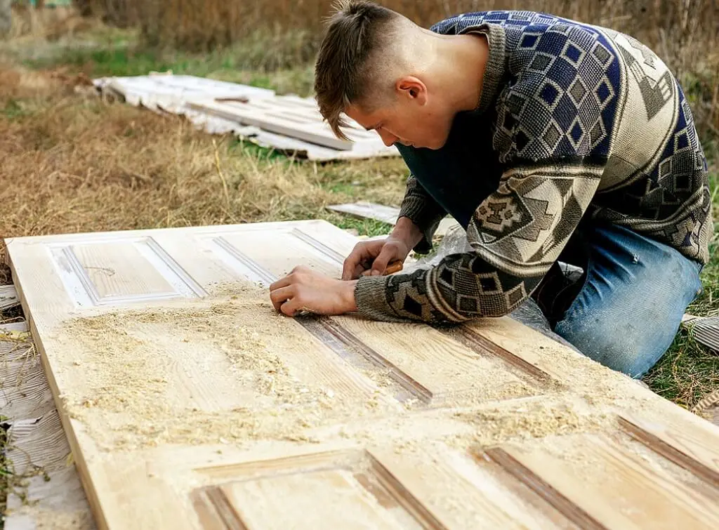 https://www.checkatrade.com/blog/wp-content/uploads/2025/01/local-tradesperson-stripping-paint-from-wooden-door.jpeg