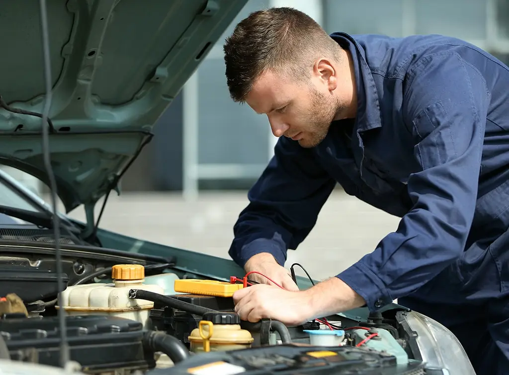 car mechanic inspecting car for a coolant leak