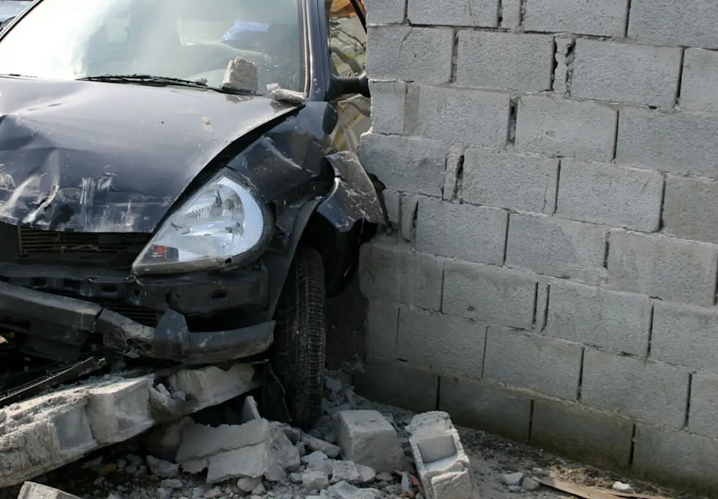 Car through a garden wall - damaged wall