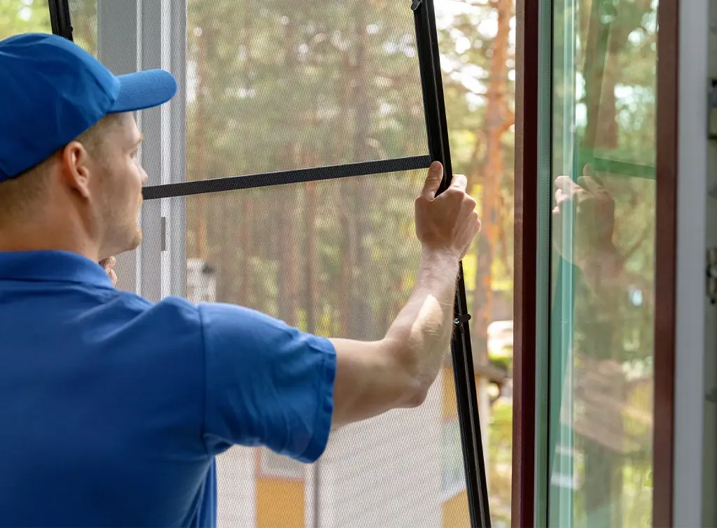 man installing window screens