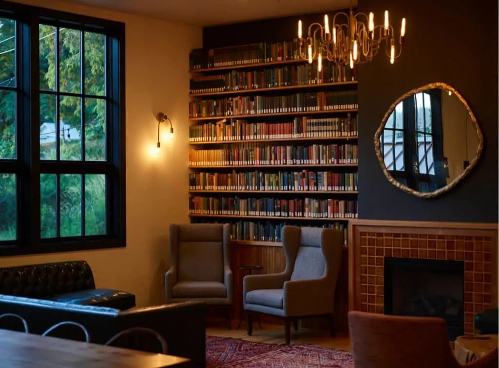 Dark and moody cottage living room idea with bookshelf and leather furniture