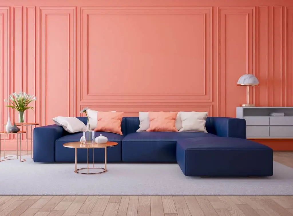 Peach walls with blue couch in bright living room