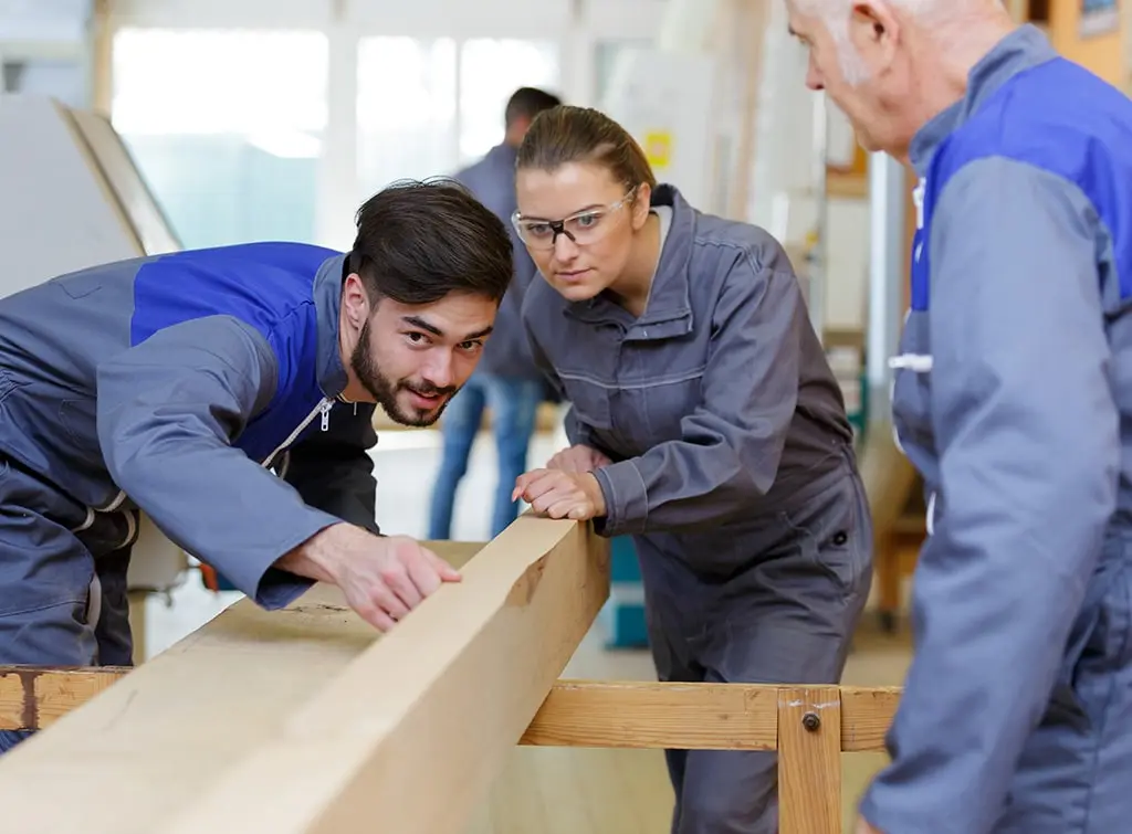 https://www.checkatrade.com/blog/wp-content/uploads/2024/02/woman-carpenter-in-training-as-apprentice.jpg