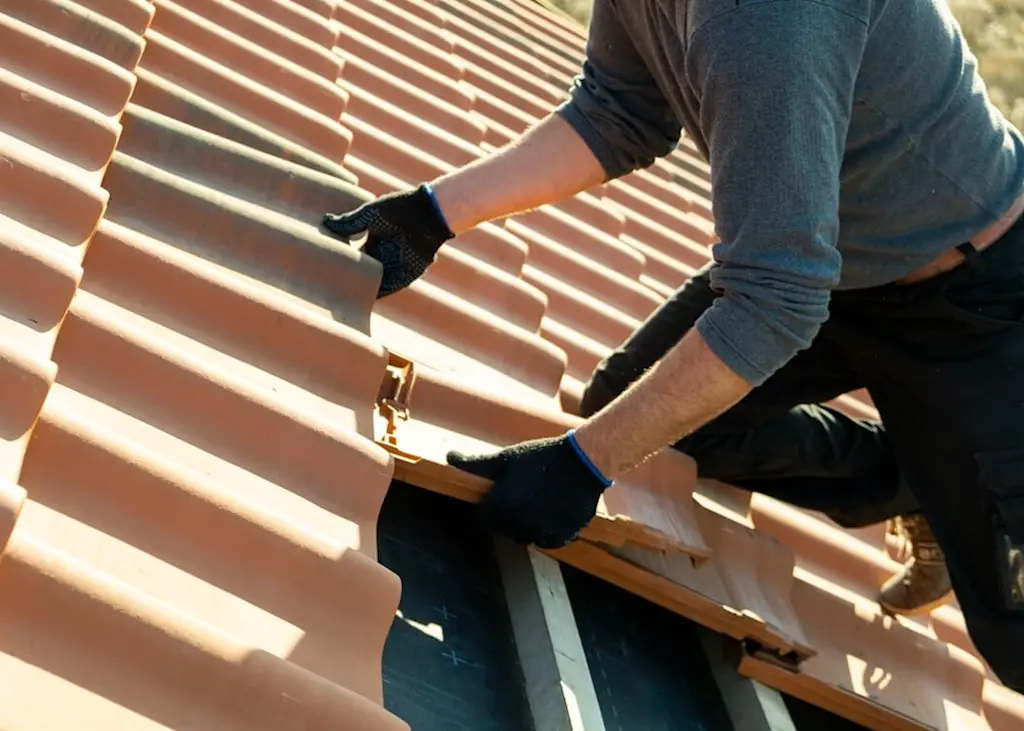Laying new clay roof tiles