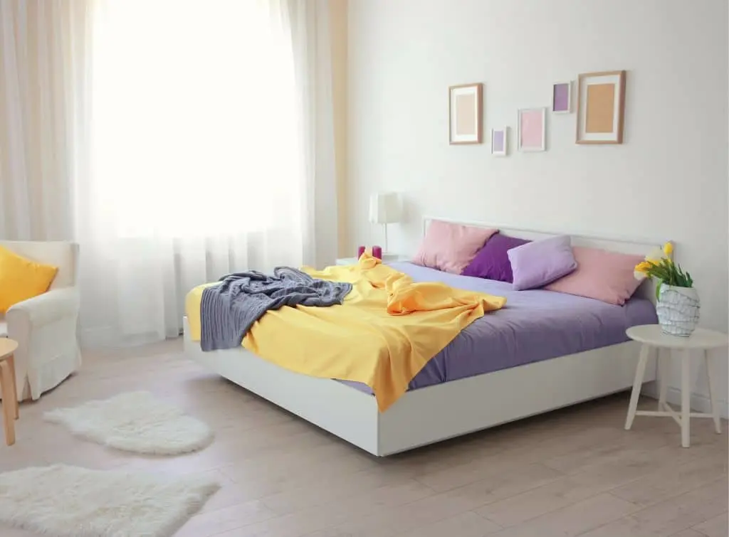 Minimalist bedroom decor with organza curtains and pastel bedding - blush, lilac, and buttercup
